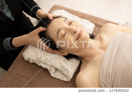 Woman receiving a head massage Woman receiving a head massage 127680082