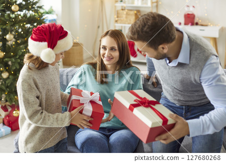 Family With Child Celebrates Christmas Or New Year With Gift Boxes At Home 127680268