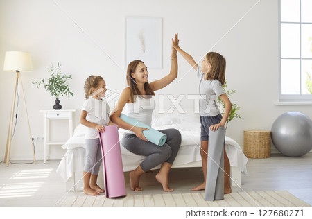 Mother High-Fiving Her Kids During A Home Fitness Workout 127680271