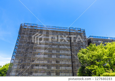 Yokohama cityscape in Japan. Apartment building repairs and inspections, scaffolding and protective nets. Satellite antennas outside the nets... Yokohama cityscape in Japan. Apartment building repairs and inspections, scaffolding and protective nets. Satellite antennas outside the nets... 127680283
