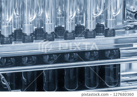 The empty dark drinking bottles on the conveyor belt for filling process. The empty dark drinking bottles on the conveyor belt for filling process. 127680360