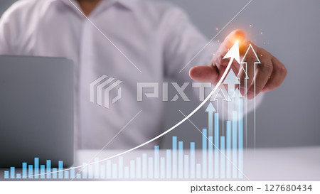 Businessman pointing at upward graph with glowing arrows, representing financial growth, success strategy, business progress, increasing revenue, investment returns, and future market opportunities. Businessman pointing at upward graph with glowing arrows, representing financial growth, success strategy, business progress, increasing revenue, investment returns, and future market opportunities. 127680434