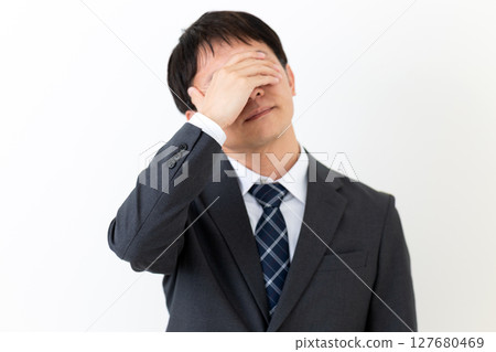 一位身著西裝、遮住臉、憂心忡忡的中年男性商人 127680469