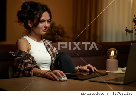 beautiful graphic designer woman working at home office remotely using digital graphic tablet and laptop 127681155