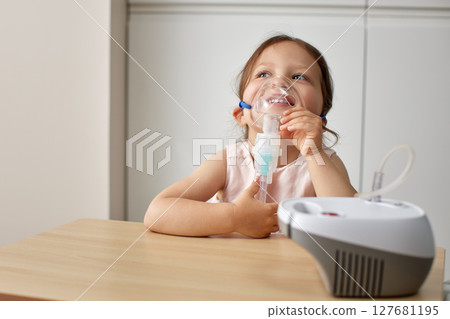 cute little toddler girl inhaling medicine on nebulizer and holding it on her own cute little toddler girl inhaling medicine on nebulizer and holding it on her own 127681195