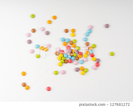 Scattered small candies isolated. Colorful dragees, multicolored glazed chocolate buttons Scattered small candies isolated. Colorful dragees, multicolored glazed chocolate buttons 127681272