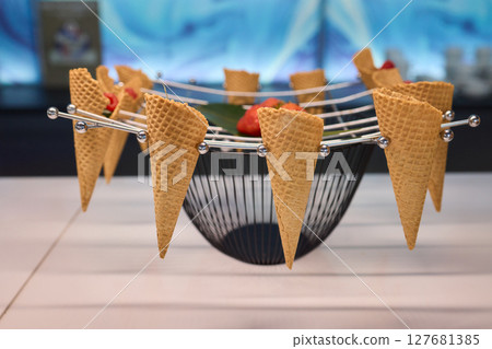 Elegant and Beautiful Dessert Presentation Featuring Ice Cream Cones Alongside Fresh Strawberries 127681385
