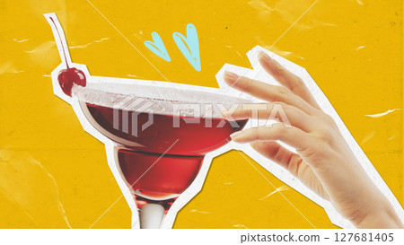 Hand reaching red cocktail glass with cherry on bright yellow background Hand reaching red cocktail glass with cherry on bright yellow background 127681405