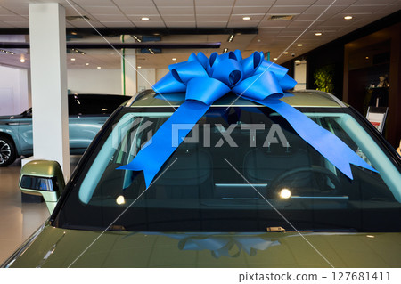 The new car is wrapped in a red bow. Beautiful gift concept. 127681411