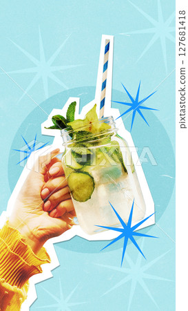 Hand holding refreshing mojito cutout with blue background and starburst accents for beverage 127681418