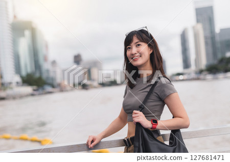 Happy Southeast Asian woman and teenager blogger explorer solo world travel. Tourism concept local cultural experience Asia, Thailand. To wait and express joy for boat Chao Phraya River Bangkok 127681471