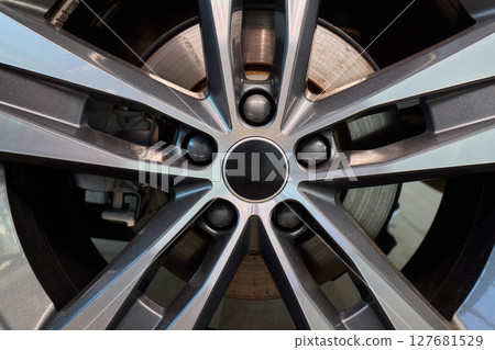 Detailed shot of a sleek black and silver alloy wheel on a motor vehicle Detailed shot of a sleek black and silver alloy wheel on a motor vehicle 127681529