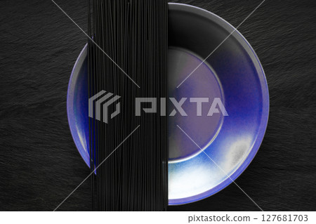 Black Spaghetti Noodles on Purple Plate Which Placed on Black Stone Surface 127681703