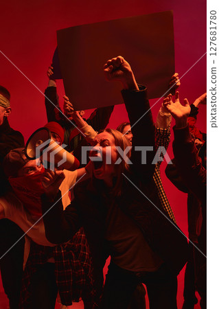 Protesters shouting slogans with megaphone against red backdrop symbolizing struggle and resistance Protesters shouting slogans with megaphone against red backdrop symbolizing struggle and resistance 127681780