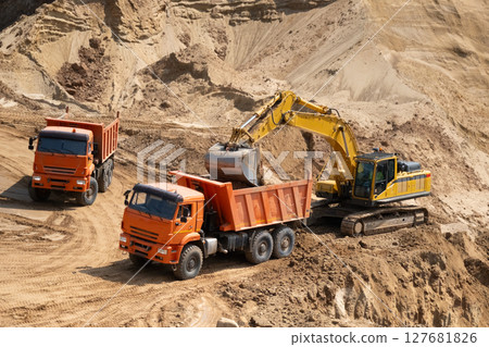 The process of loading sand in a sand quarry. Trucks are waiting for cargo. 127681826