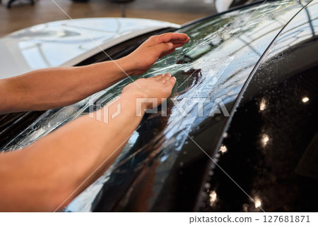 The Professional Windshield Tinting Process Conducted in a Modern Auto Showroom Environment The Professional Windshield Tinting Process Conducted in a Modern Auto Showroom Environment 127681871
