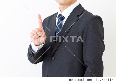 Middle-aged male businessman in a suit pointing his index finger Middle-aged male businessman in a suit pointing his index finger 127682112