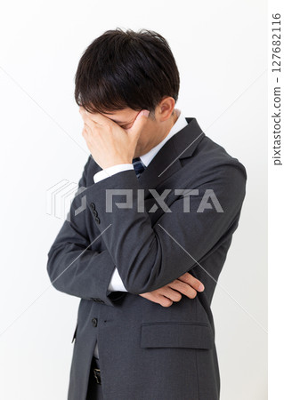 一位身著西裝、遮住臉、憂心忡忡的中年男性商人 127682116