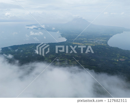 Aerial view of lush landscape and volcanic island under cloudy sky 127682311
