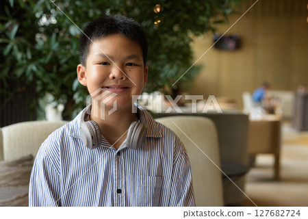 Portrait of Thai boy at cafe with headphones 127682724
