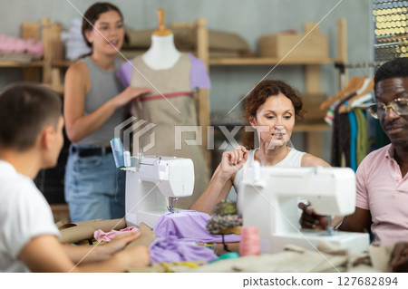 Participants in coterie practice sewing, chatting and talking, work with mannequin Participants in coterie practice sewing, chatting and talking, work with mannequin 127682894
