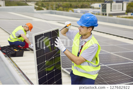 Technician Installing And Maintaining Solar Panels On Roof For Renewable Power 127682922