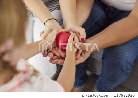 Loving happy friendly family holding red heart in hands close up, showing unity, care, support Loving happy friendly family holding red heart in hands close up, showing unity, care, support 127682926