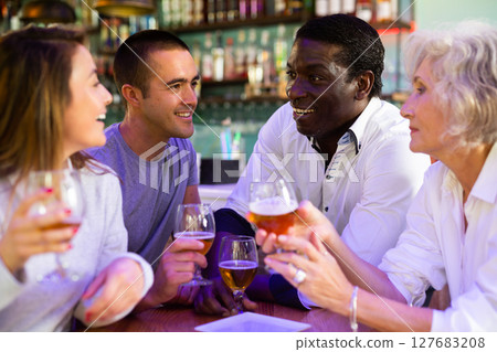 People talking and toasting in pub with the beers 127683208