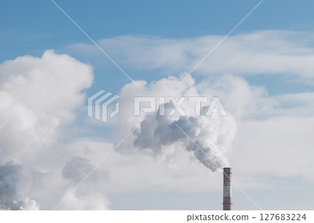 Factory chimney blowing smoke in blue sky background 127683224