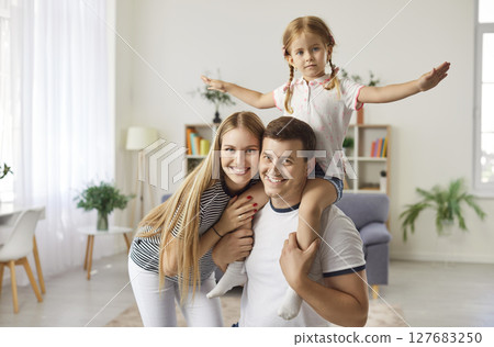 Happy playful loving family portrait, smiling laughing young parents with little daughter together 127683250