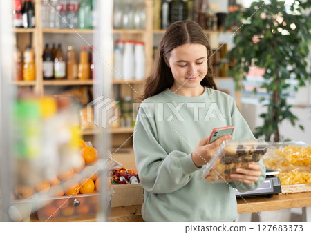Teenage girl scanning qr code of cookies 127683373