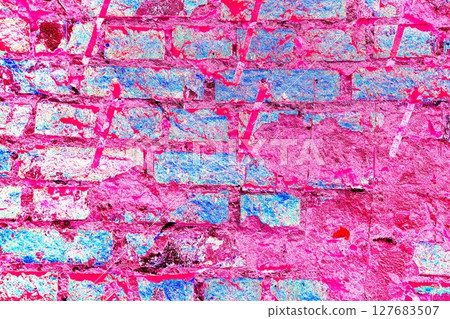 Peeling paint on a brick wall. Old brick wall with cracked peeling paint and metal pins. 127683507