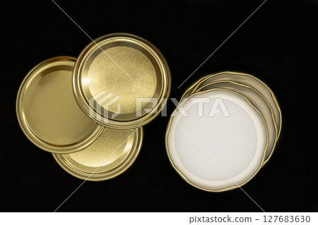 Golden jar lids isolated on black background Golden jar lids isolated on black background 127683630