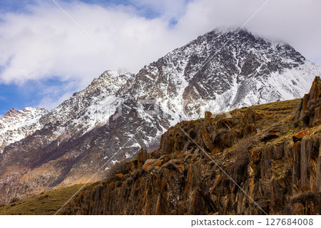 Majestic snow-capped mountain range in serene daylight 127684008