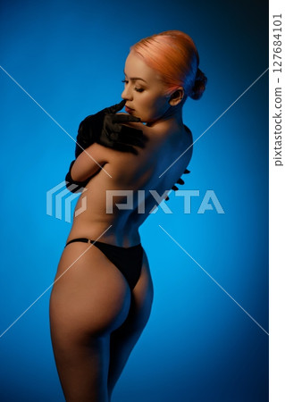 Captivating beauty in lingerie against a striking blue background 127684101