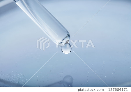 Petri dish and pipette with transparent liquid drop 127684171