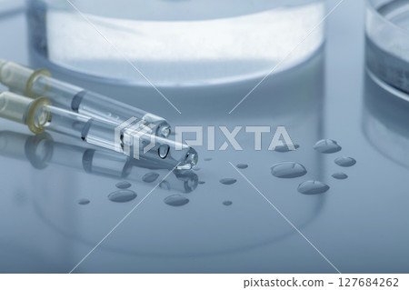 Pipettes and Petri dishes with transparent liquid on glossy background 127684262