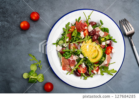 Green salad with avocado, salad leaves and jamon serrano or prosciutto 127684285