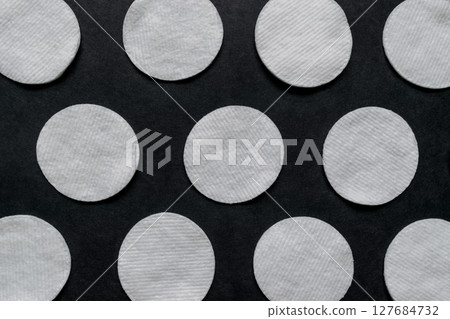 Soft, White and Round Pads on Black Background Surface 127684732
