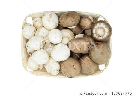 Top view of brown and white champignons mushrooms placed in wooden basket and isolated on white background 127684770