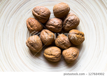 Whole Walnuts on Bamboo Plate 127684902