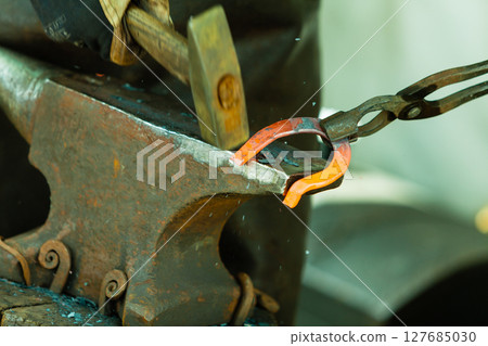 Hammering glowing steel - to strike while the iron is hot. 127685030