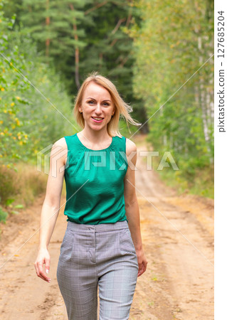 Woman walking on forest road 127685204