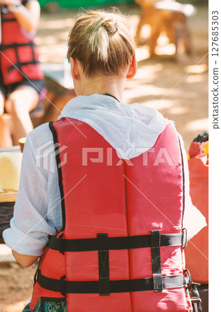 Blonde woman with red life jacket ready for swim with kayak in Thailand Blonde woman with red life jacket ready for swim with kayak in Thailand 127685303