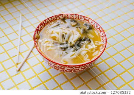 plate of noodles and chopsticks. vegetable ramen in a bright blue plate. Asian dishes. 127685322