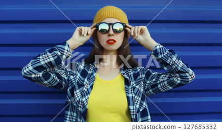 Stylish young woman in colorful clothes, modern teenage girl posing on city street 127685332