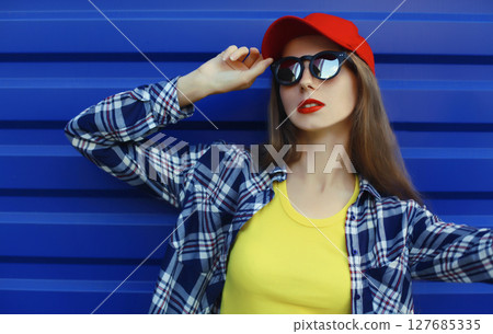 Stylish young woman in colorful clothes, modern teenage girl posing on city street 127685335