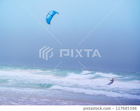 Kite surfer riding waves. Kiteboarding sport. Kite surfer riding waves. Kiteboarding sport. 127685398
