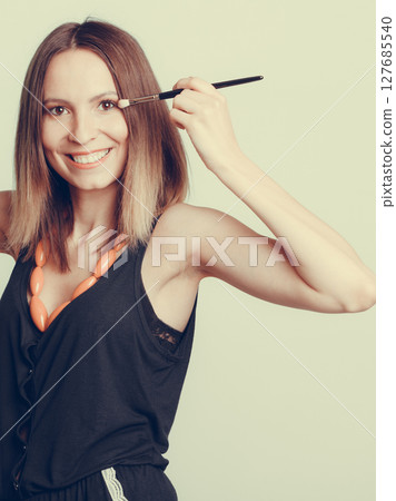 Woman stylist applying eyeshadow with brush. Woman stylist applying eyeshadow with brush. 127685540
