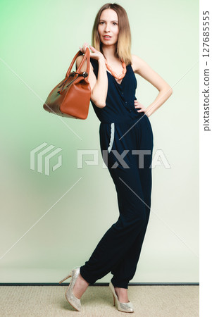 Elegant outfit. Stylish woman with brown bag 127685555